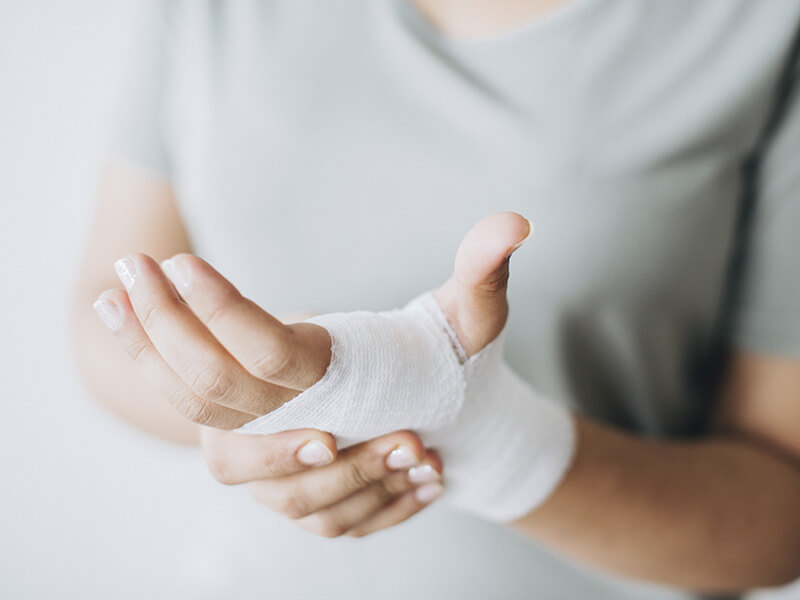 personne se tenant une main blessee avec un bandage