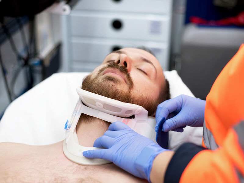 paramedical mettant un collier cervical a un homme