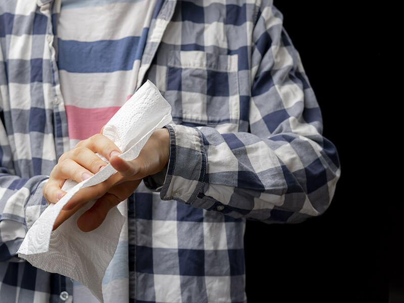 homme s'essuyant les mains avec du papier